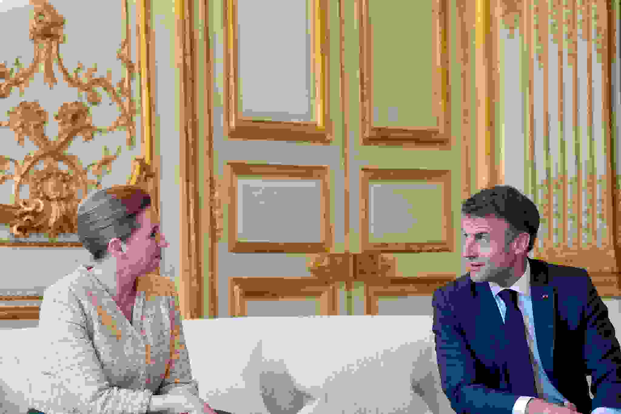 Statsminister Mette Frederiksen sidder på en sofa og taler med Frankrigs præsident Emmanuel Macron