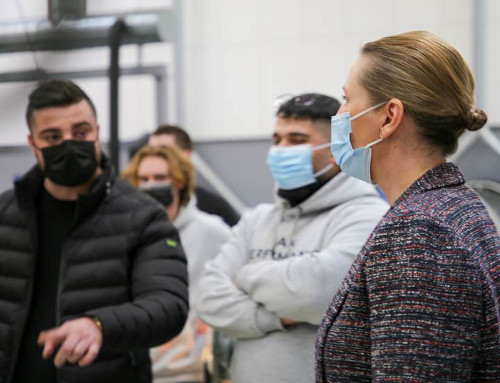 Statsminister Mette Frederiksen taler med studerende fra TEC i Hvidovre. De er iført mundbind. 
