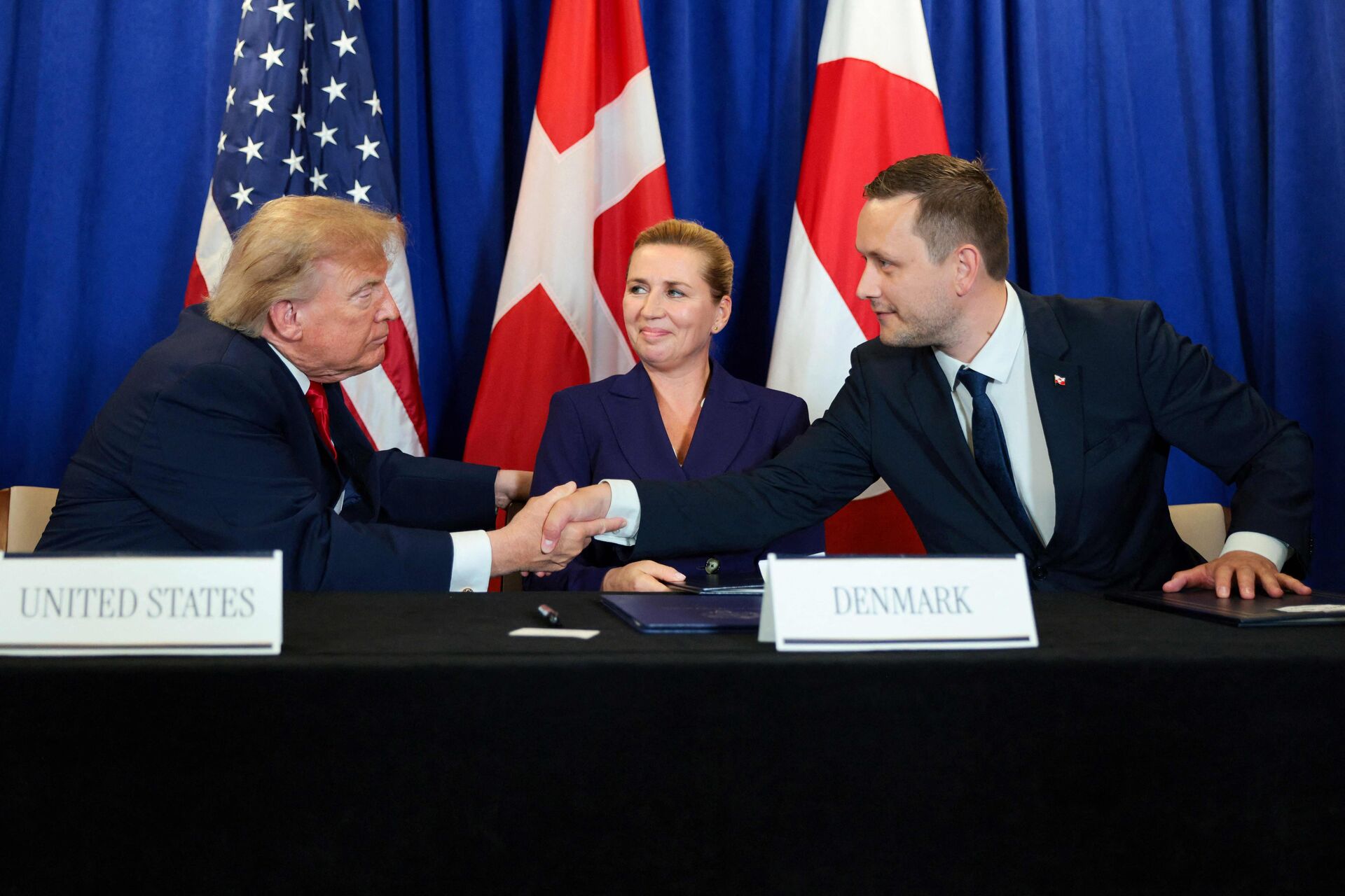 USAs præsident, statsministeren og formanden for Naalakkersuisut giver hånd, efter aftalen er underskrevet