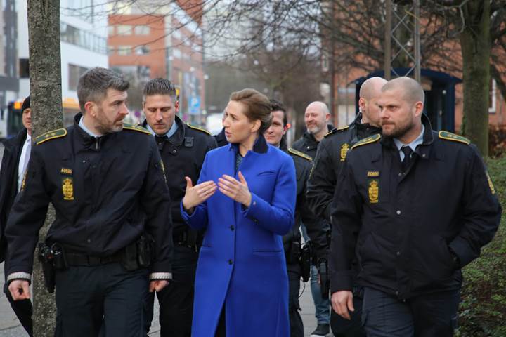 Statsminister Mette Frederiksen går og taler med en gruppe af betjente 