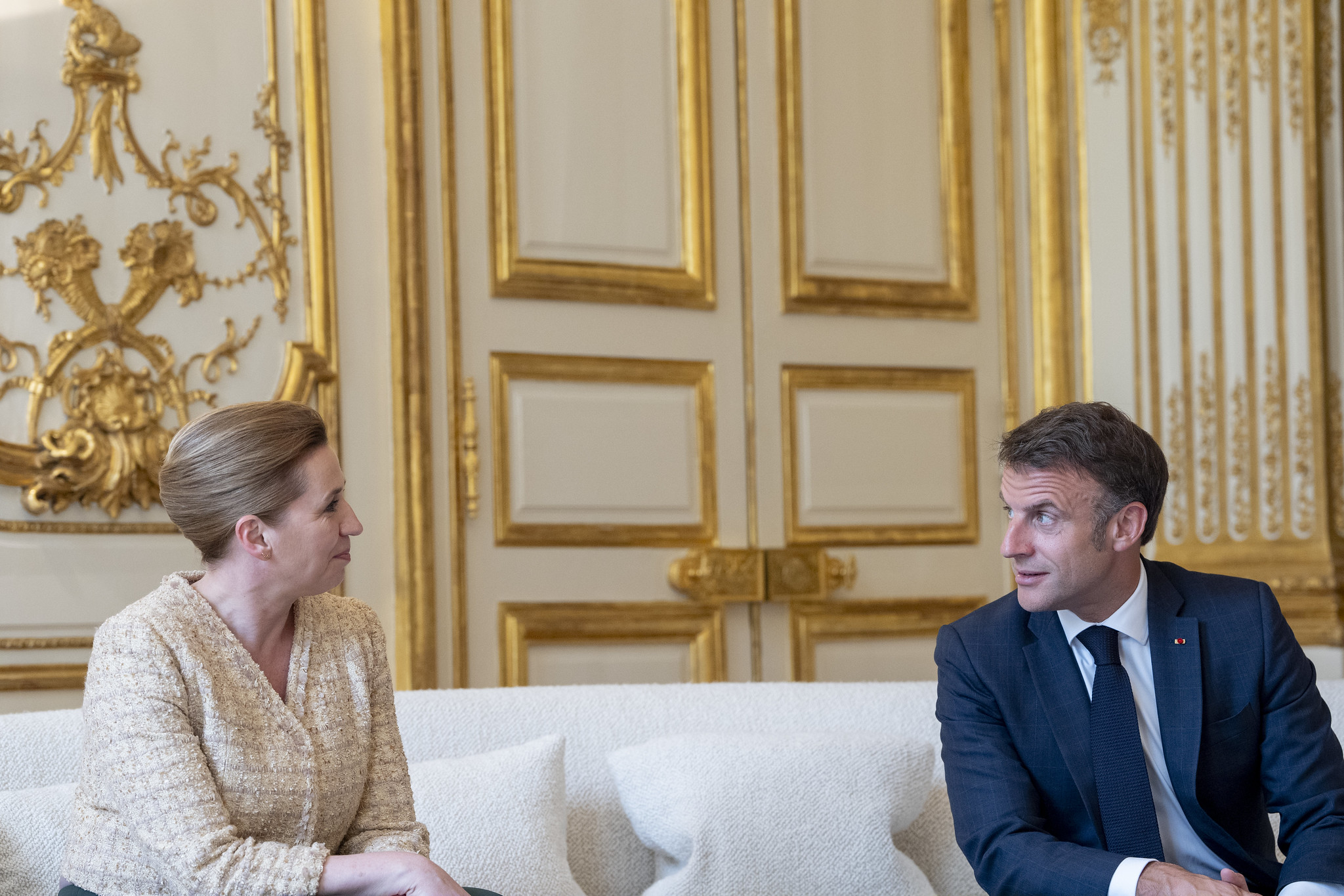 Statsminister Mette Frederiksen sidder på en sofa og taler med Frankrigs præsident Emmanuel Macron