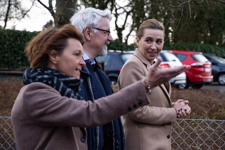 Statsminister Mette Frederiksen i samtale med to personer 