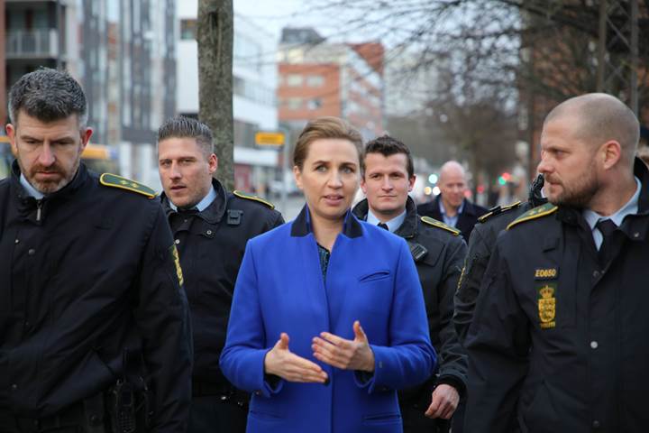 Statsminister Mette Frederiksen går og taler med en gruppe af betjente 