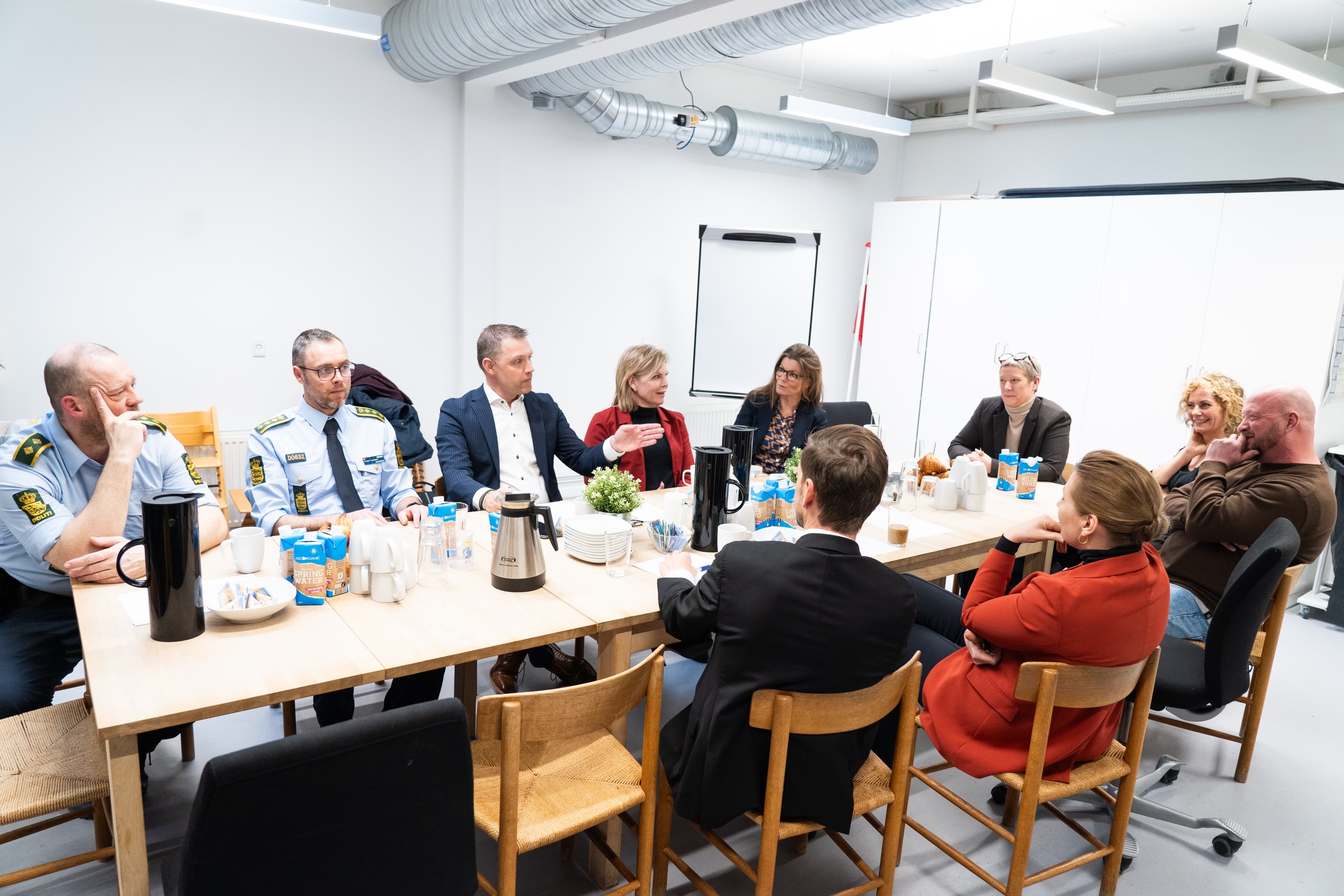 Deltagere ved besøget samtaler ved bordet