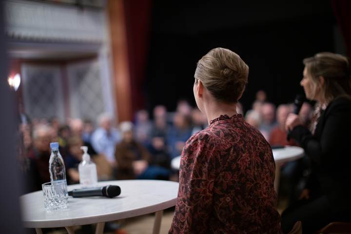 Statsminister Mette Frederiksen sidder ved et rundt bord, hvorfra hun svarer på spørgsmål fra Fyns Amts Avis' læsere. 