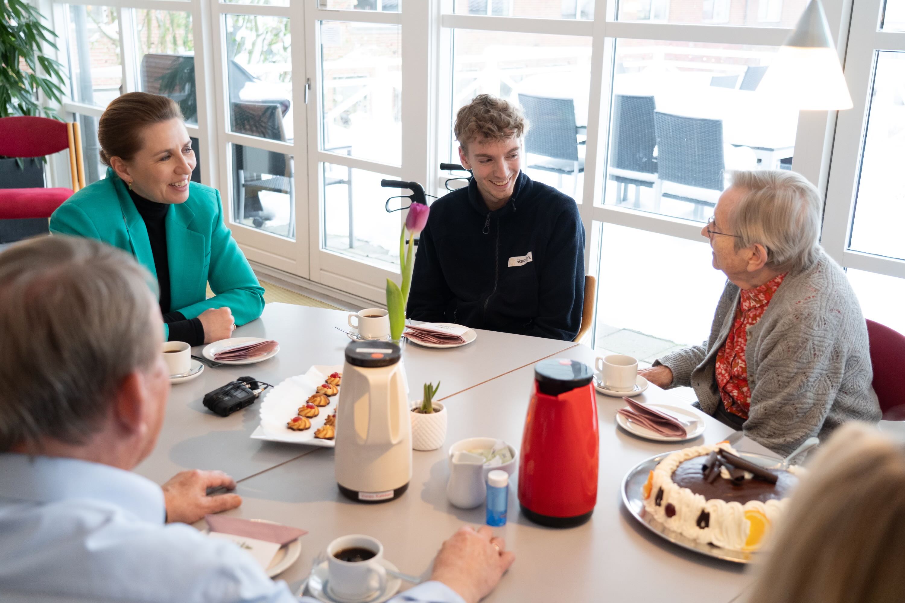 Statsminister Mette Frederiksen sammen med plejevikar og borger på Plejecenter Tjørnehaven